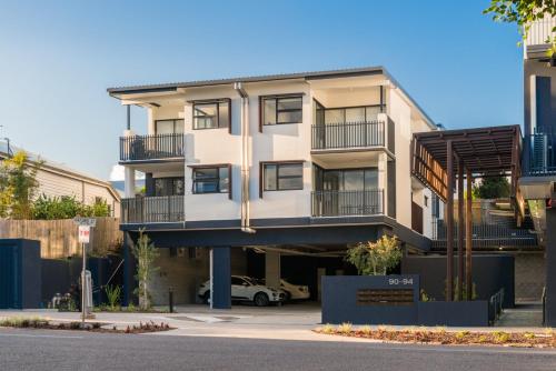 an apartment building with a car parked in a parking lot at Oxford Steps - Executive 2BR Bulimba Apartment Across from the Park on Oxford St in Brisbane