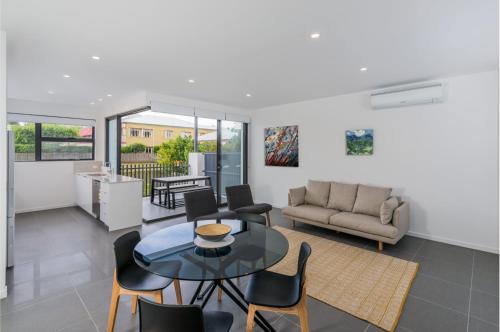 a living room with a table and chairs at Oxford Steps - Executive 2BR Bulimba Apartment Across from the Park on Oxford St in Brisbane