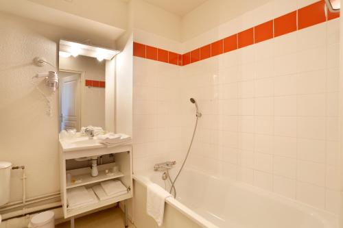 ein Badezimmer mit einer Badewanne und einem Waschbecken in der Unterkunft Vacancéole - Les Demeures Champenoises Confort in Épernay