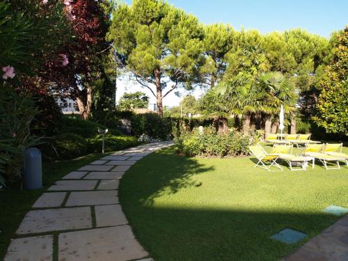 a garden with a table and chairs on the grass at Hotel Giulietta Romeo in Lazise