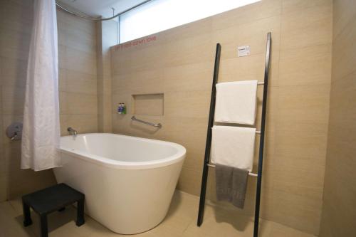 a bathroom with a tub, toilet and sink at The Tides Hotel Boracay in Boracay