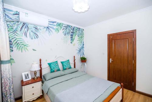 a bedroom with a bed with blue and green pillows at Henan Luoyang·Henan University of Science And Technology· Locals Apartment 00150340 in Luoyang