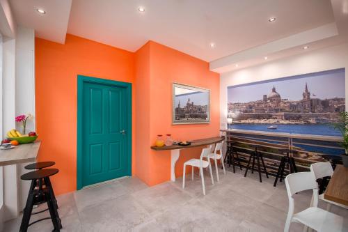 グジラにあるIsland Guesthouseのオレンジ色の壁と緑のドアが特徴の客室