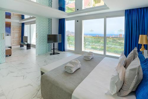 Habitación grande con cama y ventanas grandes. en Grand Luxor Hotel, en Benidorm