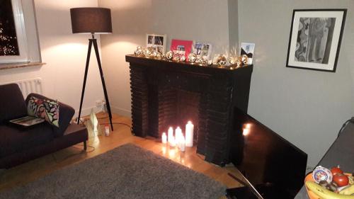 a living room with a fireplace with candles in it at Office des bons enfants in Huy