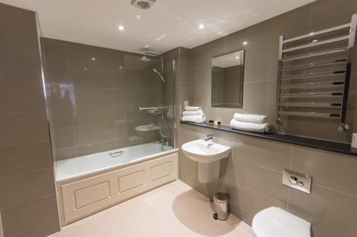 a bathroom with a toilet, sink, and bathtub at St Nicholas Hotel in Colchester