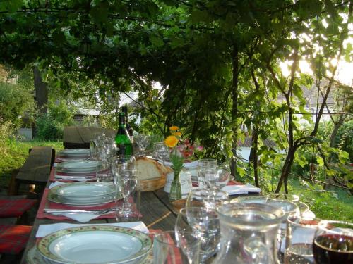 a long table with plates and glasses on it at Count Kálnoky's Transylvanian Guesthouses in Micloşoara