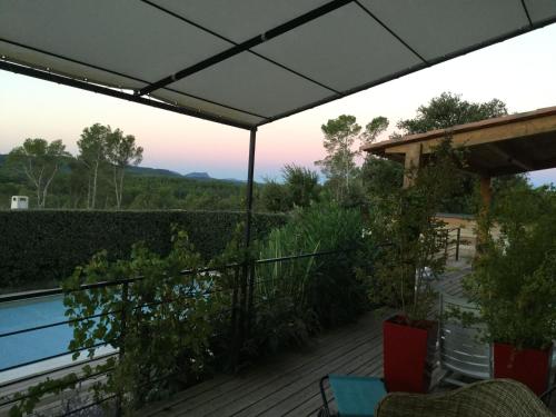 a deck with an umbrella and a view of the mountains at Villa Chamarel in Carcès