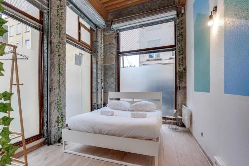 um quarto com uma cama e uma grande janela em NOCNOC - Le Canut em Lyon
