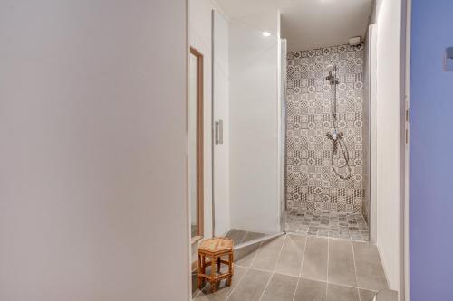 uma casa de banho com um chuveiro e um banco num quarto em NOCNOC - Le Canut em Lyon