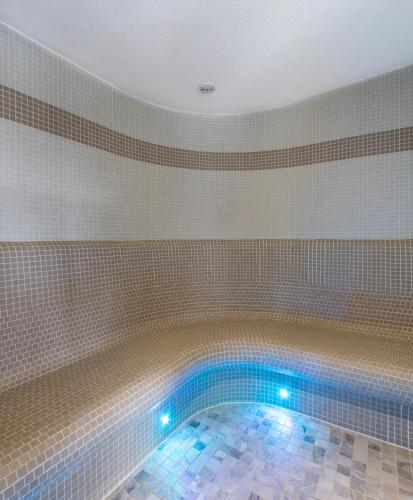 a swimming pool with blue lights in a tiled wall at Hotel&Wellness Knížecí rybník in Tábor