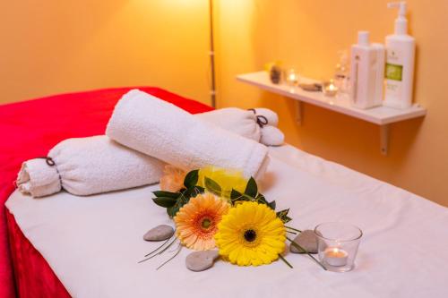 a hotel room with towels and flowers on a bed at Hotel&Wellness Knížecí rybník in Tábor