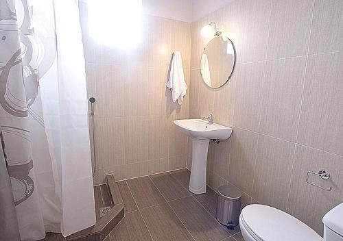 a bathroom with a sink and a toilet and a shower at Galazia Nera Apartments in Áyios Andréas Messinias