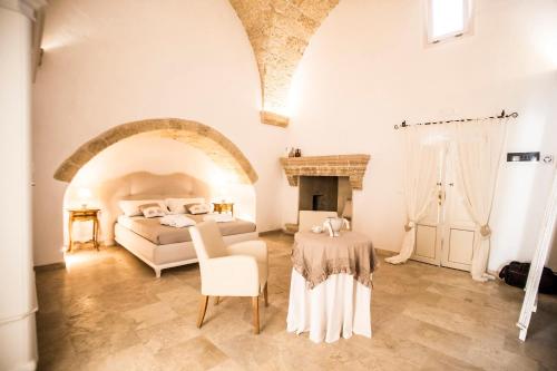 a bedroom with a bed and a table in a room at Corte di Bonifacio - Luxury Suites in Casarano