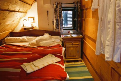 a bedroom with a bed and a table and a window at Count Kálnoky's Transylvanian Guesthouses in Micloşoara