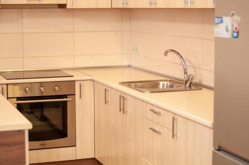 a white kitchen with a sink and a stove at Prestige Apartments Kalnyshevskogo in Dnipro