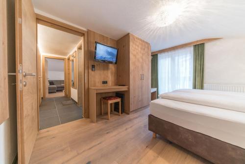 a hotel room with a bed and a television at Das Hochegg - Apartments in Obergurgl