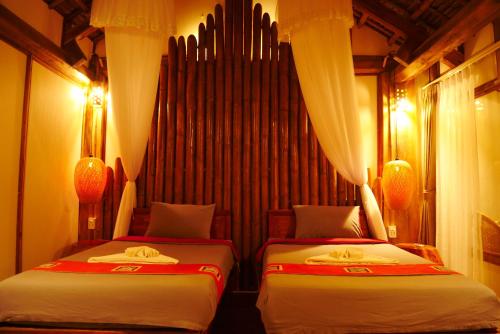 two beds sitting in a room with lights at Puluong Home in Pu Luong