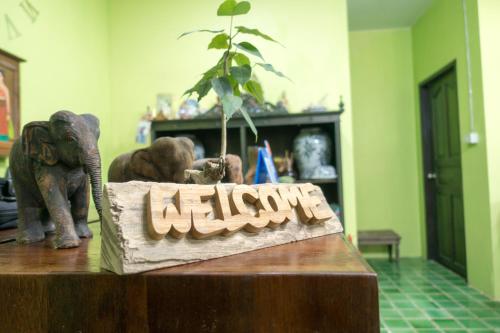 a table with two elephants and a sign that says library at Plus Hostel Ayutthaya in Phra Nakhon Si Ayutthaya