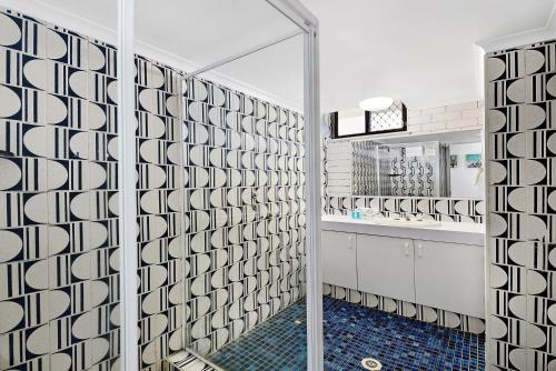 a bathroom with a shower with a glass door at Broadbeach Travel Inn Apartments in Gold Coast