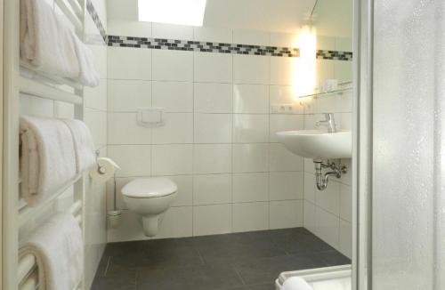 ノルダーナイにあるApartment mit Meerblickの白いバスルーム(トイレ、シンク付)