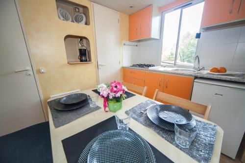 a kitchen with a table with plates and flowers on it at Toscana Holiday Village in Montopoli in Val dʼArno