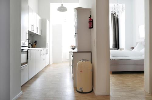 a white kitchen with a suitcase in the middle of a room at SC 2 Cozy Family & Business Flair welcomes you - Rockchair Apartments in Berlin