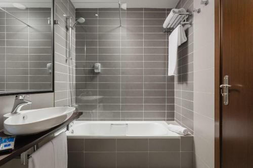 a bathroom with a white tub and a sink at Hotel Asset Torrejón in Torrejón de Ardoz