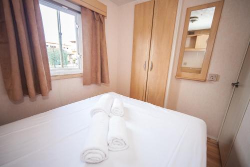 a bedroom with a white bed with towels on it at Toscana Holiday Village in Montopoli in Val dʼArno