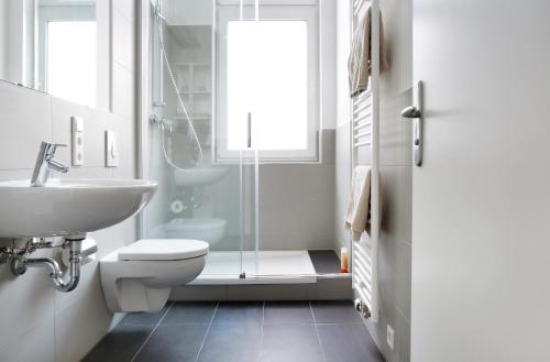 a bathroom with a toilet and a sink and a shower at SC 2 Cozy Family & Business Flair welcomes you - Rockchair Apartments in Berlin