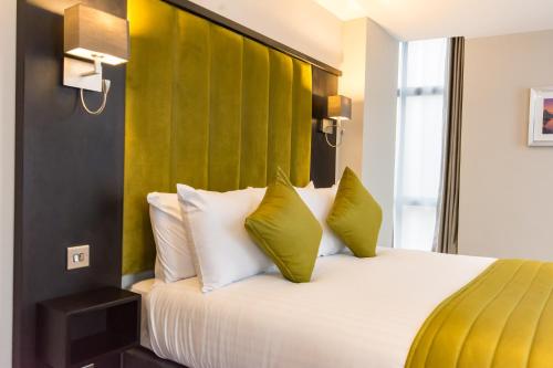 コルチェスターにあるSt Nicholas Hotel Colchesterのベッドルーム1室(大型ベッド1台、黄色と白の枕付)