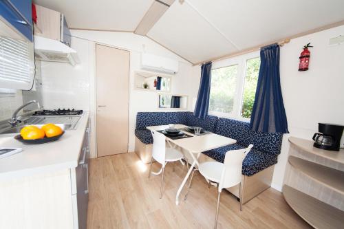 a kitchen with a table and chairs in a caravan at Toscana Holiday Village in Montopoli in Val dʼArno