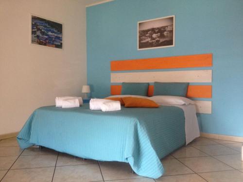 a bedroom with a bed with an orange and blue at Platamone Rooms in Catania