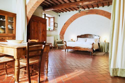 a bedroom with a bed and a table and chairs at Agriturismo Villa Mazzi in Montepulciano