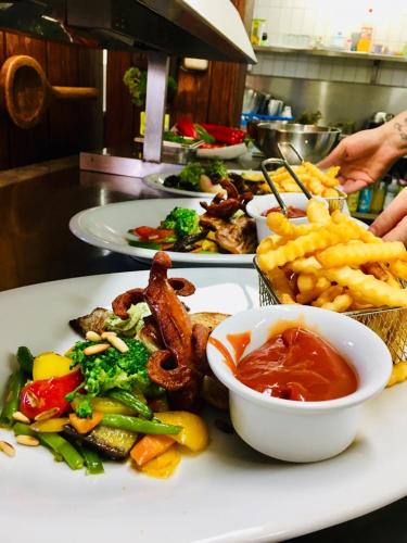 a plate of food on a table with french fries at Hotel und Restaurant Post Prienbach in Stubenberg