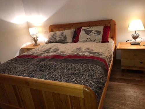 a wooden bed in a bedroom with two night stands at LA TANA DEL LUPO in Roccaraso