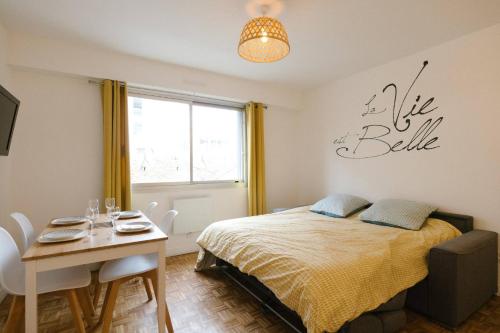 a bedroom with a bed and a table and a table and chairs at La vie est belle - Longchamps-Canebière-Gare in Marseille