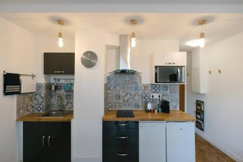 une cuisine avec un évier et une cuisinière dans l'établissement La vie est belle - Longchamps-Canebière-Gare, à Marseille