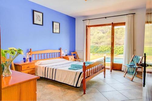 a blue bedroom with a bed and a window at Villa Cadí . Ref. 620 in Tamariu