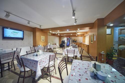 ein Esszimmer mit Tischen und Stühlen sowie einem TV in der Unterkunft Hotel Akcinar in Istanbul