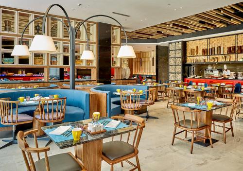 a dining room with tables and chairs in a restaurant at Dusit Thani Shuangyue Bay Resort Huizhou in Huidong