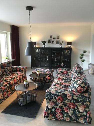 Una sala de estar con un sofá y dos mesas. en Apartement Merlin, en Wilhelmshaven
