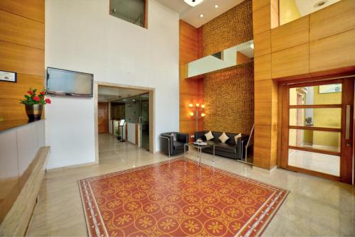 a lobby with a couch and a table in a building at Coraltree Hotel Bangalore in Bengaluru