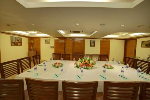 a large table in a room with chairs and flowers at Coraltree Hotel Bangalore in Bengaluru