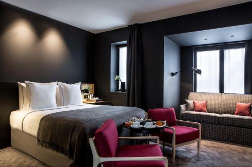 une chambre d'hôtel avec un lit, une table et des chaises dans l'établissement Hôtel Louvre-Lens - Esprit de France, à Lens