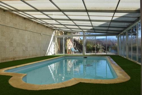 einen Pool in einem Gebäude mit einer Decke in der Unterkunft CASA RURAL MARY in Villalba Baja