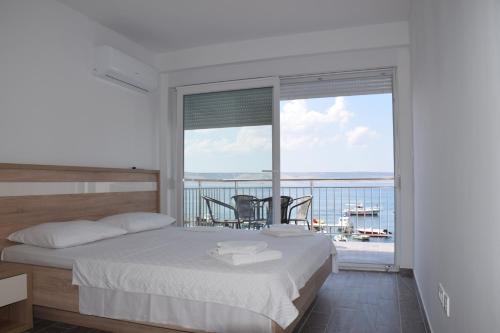 1 dormitorio con cama y vistas al océano en Apartments Tota, en Starigrad-Paklenica