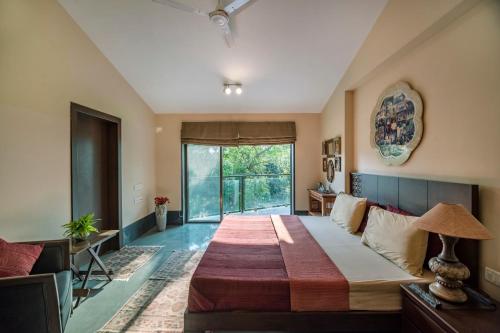 a bedroom with a large bed and a couch at SaffronStays Masaya, Alibaug - pet-friendly villa with alfresco dining in Alibaug