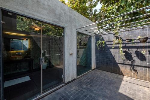 a pivoting glass door of a house at SaffronStays Masaya, Alibaug - pet-friendly villa with alfresco dining in Alibaug