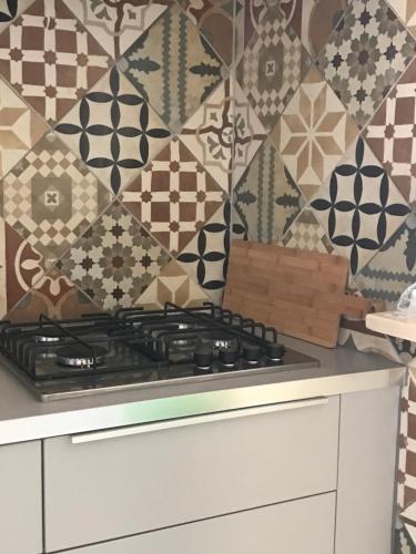 a kitchen with a stove and a patterned wall at Casa Alameda in Portimão